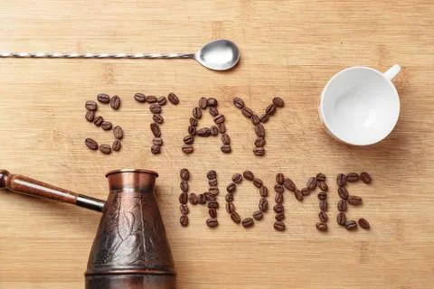 Roasted coffee beans, a twisted spoon, a copper cezva and a white porcelain cup 스톡 사진