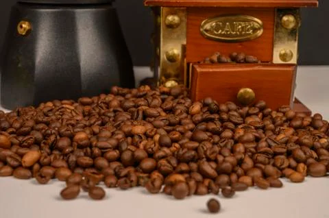 Roasted coffee beans on white background with coffee grinder and coffee maker Stock Photos
