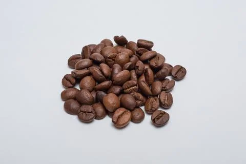 Roasted coffee beans on a white background. Stock Photos