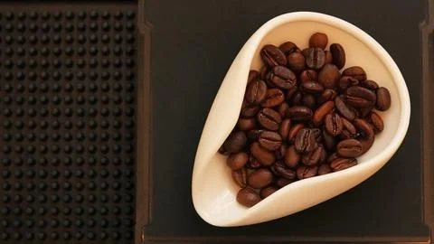 Roasted coffee beans in a white dosing tray Stock Photos