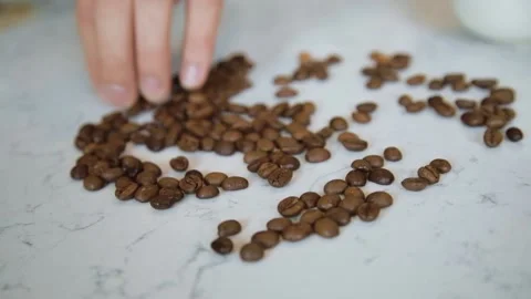 Roasted coffee beans on a white marble table background. Stock Footage 161112051
