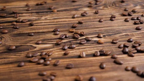 Roasted coffee beans on a wooden table. Slow motion. Stock Footage 129592591