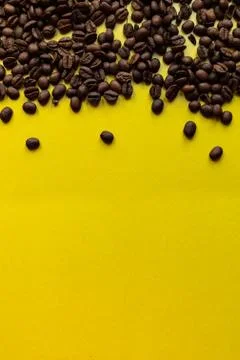 Roasted coffee beans with a yellow background. Stock Photos