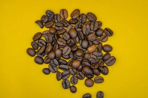 Roasted coffee beans on yellow background Stock Photos