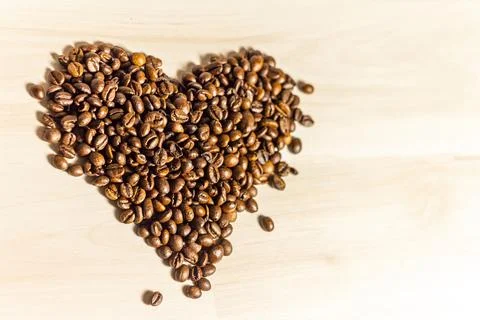 Roasted coffee grains lying in the shape of the heart Stock Photos
