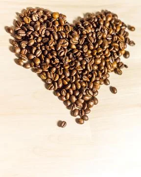 Roasted coffee grains lying in the shape of the heart Foto stock