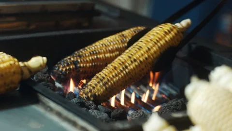 Roasted corn-cobs on brazier grid at the street Видео 117796213