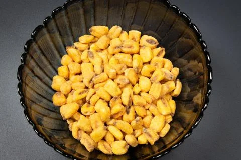 Roasted corn nuts in plate on dark background Stock Photos