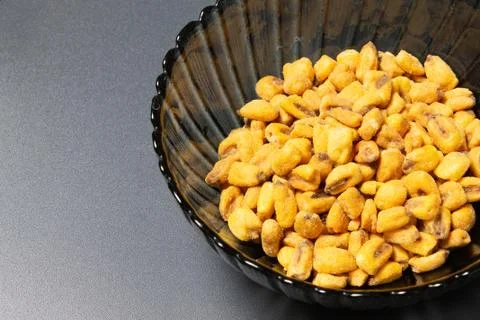 Roasted corn nuts in plate on dark background Foto stock