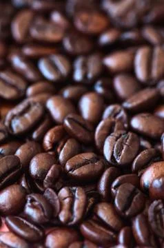 Roasted dark coffee beans background. Close up. Stock Photos