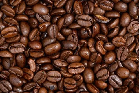 Roasted dark coffee beans background from close up. Stock Photos