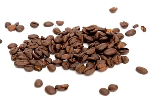 Roasted dark coffee beans spread out on white underground Foto stock