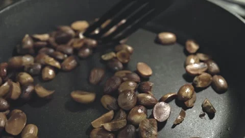 Roasted Delights: Toasting Aromatic Nuts in a Skillet Stock Footage 262007606