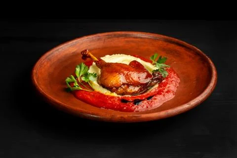 Roasted duck leg with mashed potatoes and tomato sauce. Photos