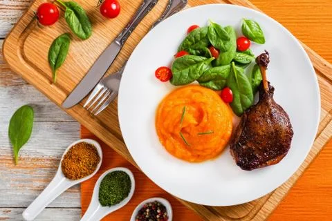 Roasted duck leg with mashed pumpkin and salad Foto stock