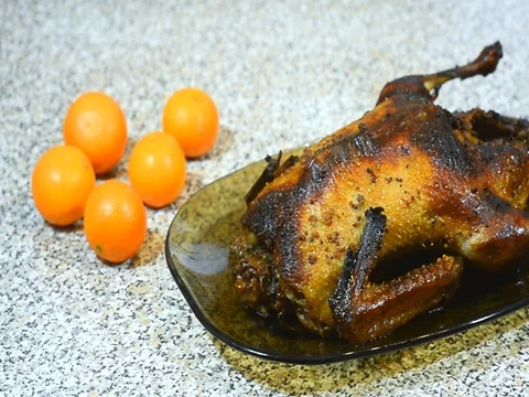 Roasted duck on a platter next to mandarins Stock Footage 72699678