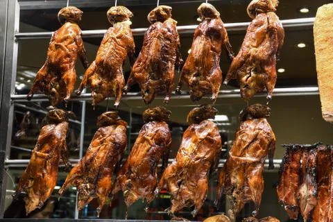 Roasted ducks hanging on rack showcase Stock Photos