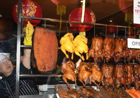 Roasted ducks hanging on rack showcase Stock Photos