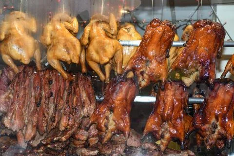 Roasted ducks hanging on rack showcase Stock Photos