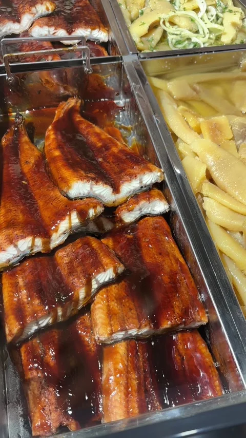 Roasted eel fillets with kabayaki glaze in a stainless steel tray. Vertical 스톡 동영상 325649327