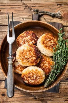 Roasted fish cutlets or patty in a wooden plate. wooden background. Top view Stock Photos