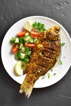 Roasted fish on plate Stock Photos