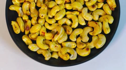 Roasted golden cashew nuts in black plate, top view Stock Footage 336471107