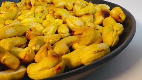 Roasted golden cashew nuts in black plate, close-up shot Stock Footage 336471109