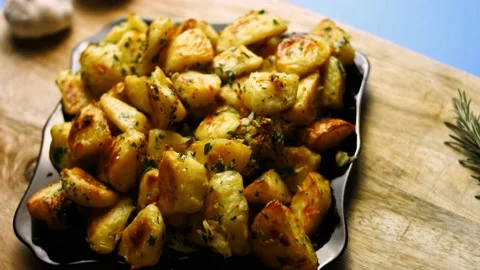 Roasted golden potatoes spiced with fried garlic and rosemary and fresh parsley Stock Footage 151343280