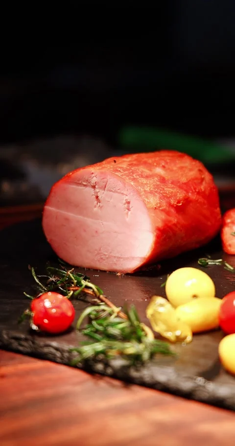 Roasted Ham with Rosemary and Tomatoes on Dark Board Видео 326680986