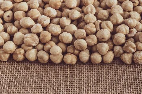 Roasted hazelnuts on a background of burlap. Heap of nut kernels. Copy space Foto stock