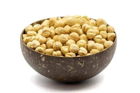 Roasted hazelnuts isolated on white background. Nuts in a coconut bowl. Studi Stock Photos