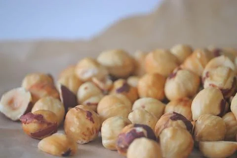 Roasted hazelnuts in a rustic scatter featuring whole and split filbert ker.. 写真素材