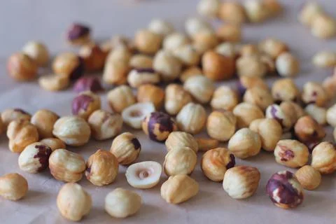Roasted hazelnuts in a rustic scatter featuring whole and split filbert ker.. Stockfoto's