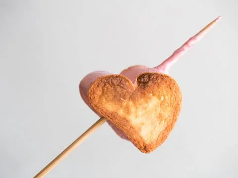 Roasted heart form marshmallows on a skewer on white background Stock Photos