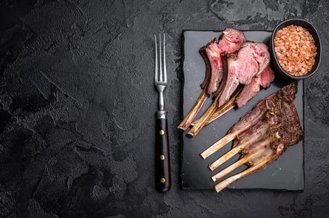 Roasted lamb chops steaks, mutton meat cutlets. black background. top view Stock Photos