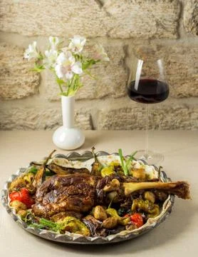 Roasted lamb shoulder served with roasted tomato, aubergine and bell peppers Stock Photos
