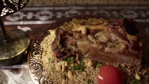 Roasted Lamb on Spiced Rice with Nuts and Tomato in Ornate Turkish Arabic Stock Footage 345953309