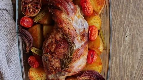 Roasted leg of lamb with vegetables, top view Stock Footage 250686283