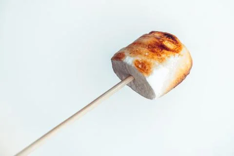 Roasted marshmallows on a skewer on white background Stock Photos