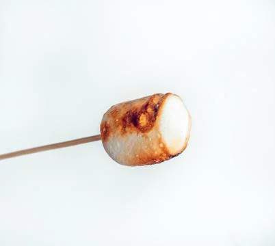 Roasted marshmallows on a skewer on white background Stock Photos