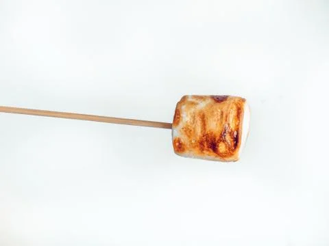 Roasted marshmallows on a skewer on white background Stock Photos