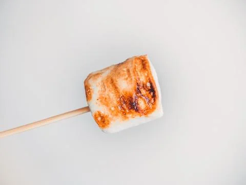 Roasted marshmallows on a skewer on white background Stock Photos
