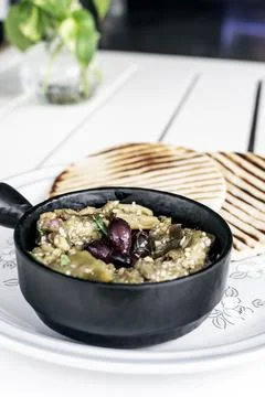 Roasted mashed Eggplant tapas snack on white table in outdoor restaurant in.. Stockfoto's