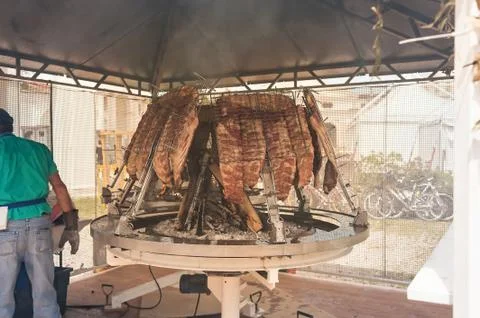 Roasted meat of beef cooked on a vertical grills. Stock Photos