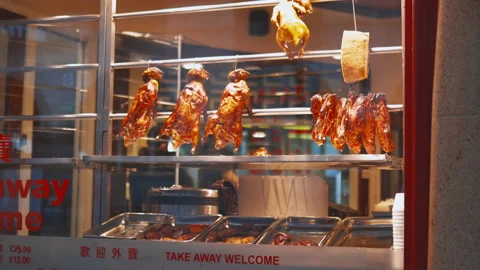Roasted meat hanging behind the window of a Chinese restaurant Stock Footage 143262780