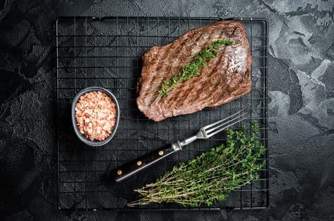 Roasted medium rare flank beef steak with thyme. Black background. Top view Stock-Fotos