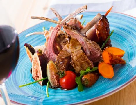 Roasted mutton ribs with figs, vegetables, demi-glace and red wine Stock Photos