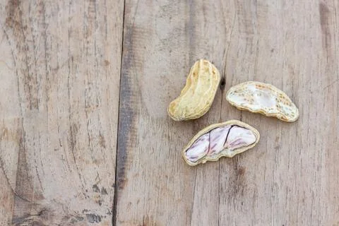 Roasted or row peanuts scattered on rustic, dark wood table background. Foto stock