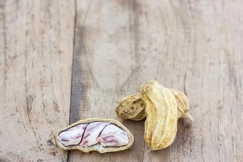 Roasted or row peanuts scattered on rustic, dark wood table background. Foto stock